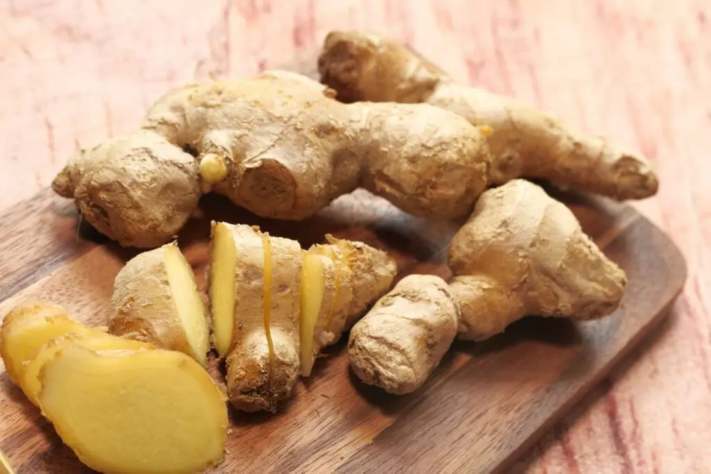 A wooden cutting board with ginger on it.