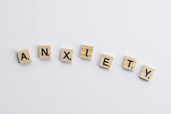 Wooden tiles on a white background spell anxiety, symbolizing mental health awareness.